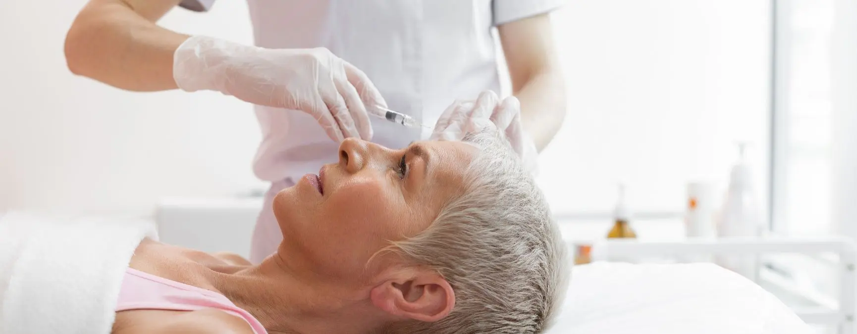 Person in a medical office receiving a Botox injection in their forehead to help reduce migraine symptoms.