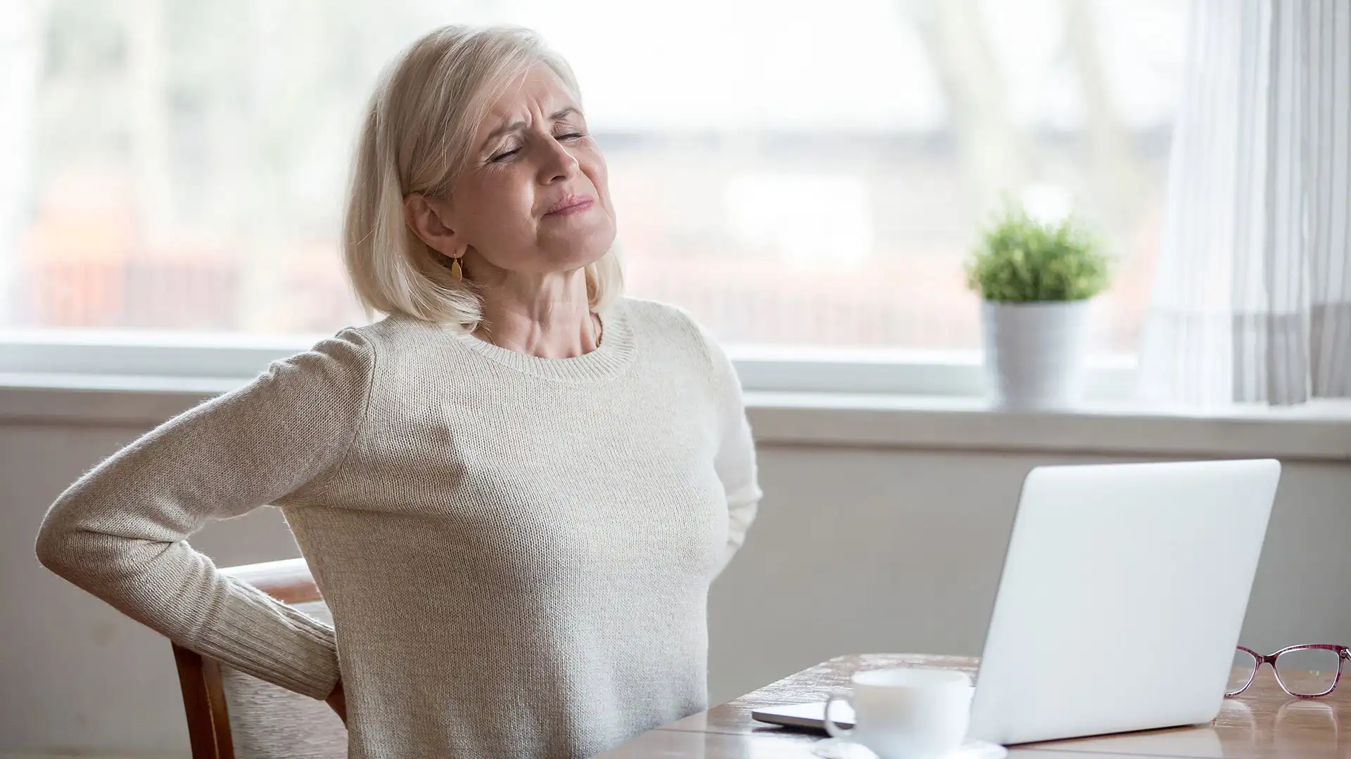Elderly woman experiencing lower back pain