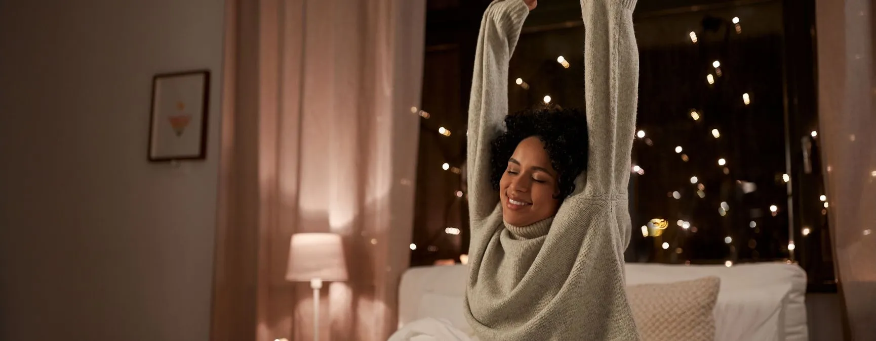Person with warm sweater stretching arms over head to prevent neck pain.