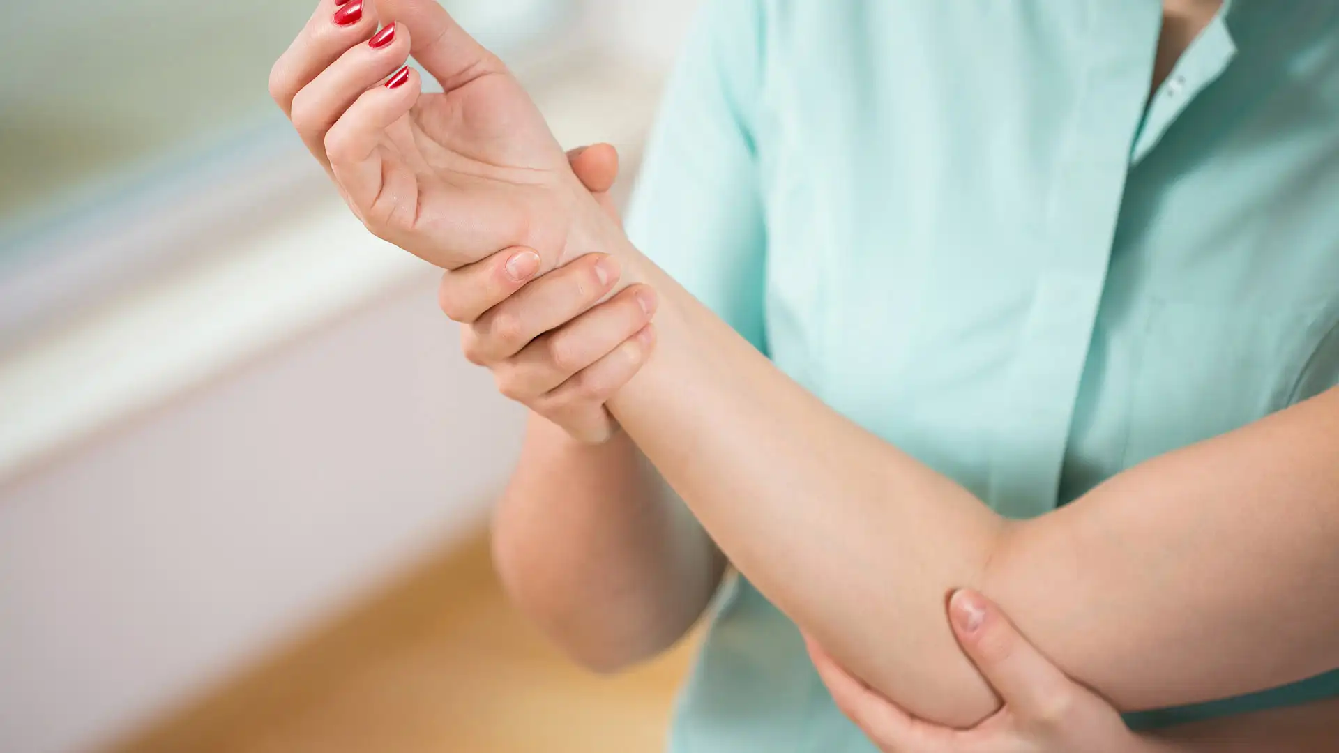 Doctor diagnosing painful elbow of young woman